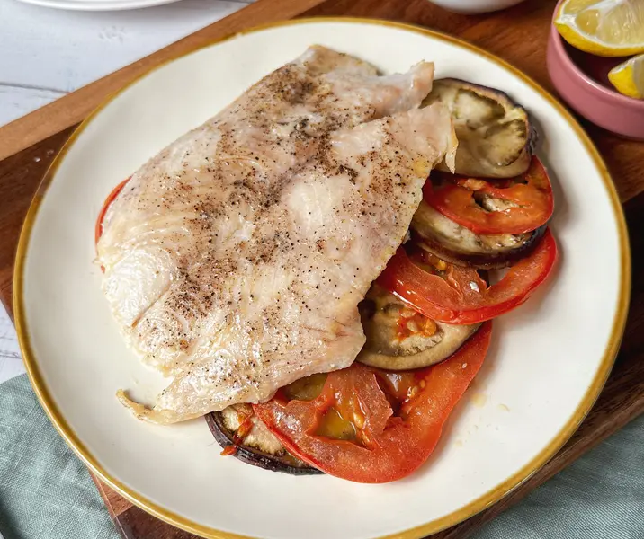 Reineta al horno con tomates y berenjenas asadas