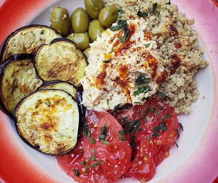 Quínoa con berenjenas, hummus, tomate y aceitunas