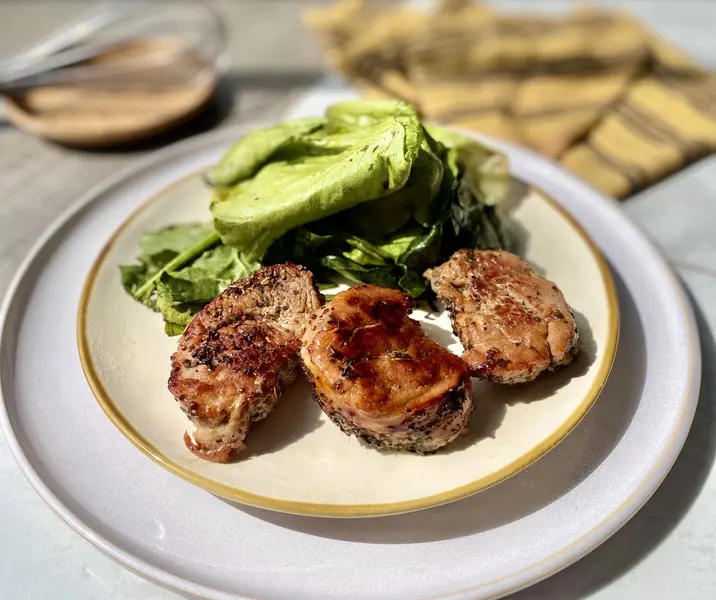 Filetes de cerdo glaseados con mermelada y hojas verdes