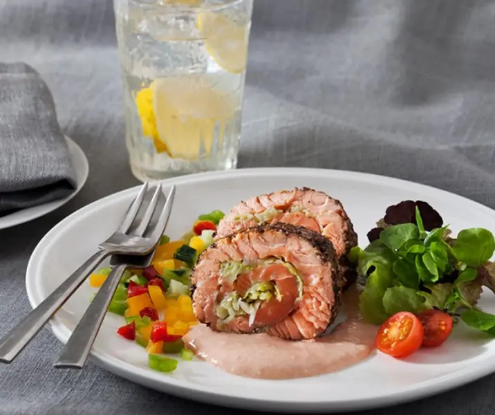 Rollo frío de salmón relleno y sellado a la pimienta con papas duquesas y ensalada verde con palta