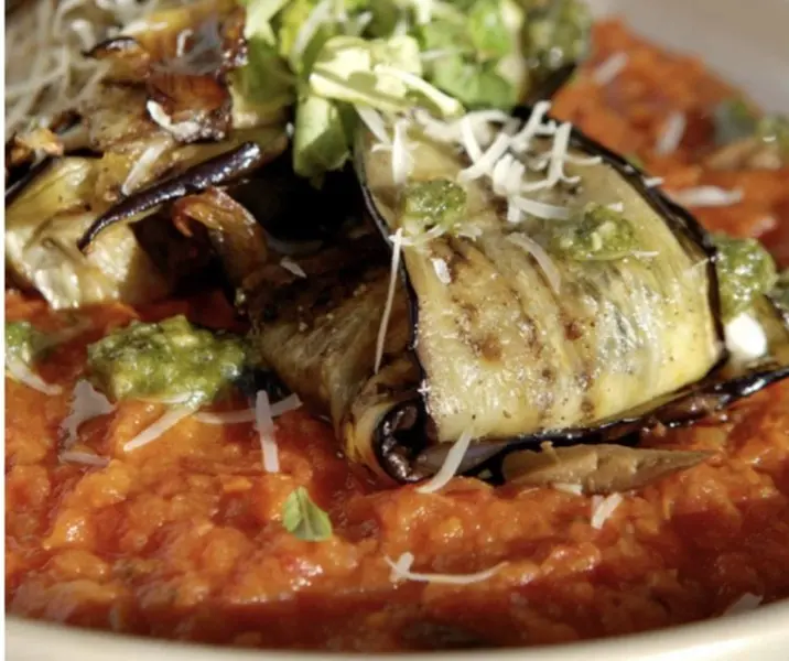 Paquetitos de zapallo italiano y berenjenas rellenos de queso de cabra sobre salsa de tomate casera