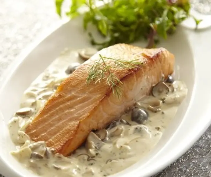 Salmón con salsa de champiñones acompañado de mix de hojas verdes
