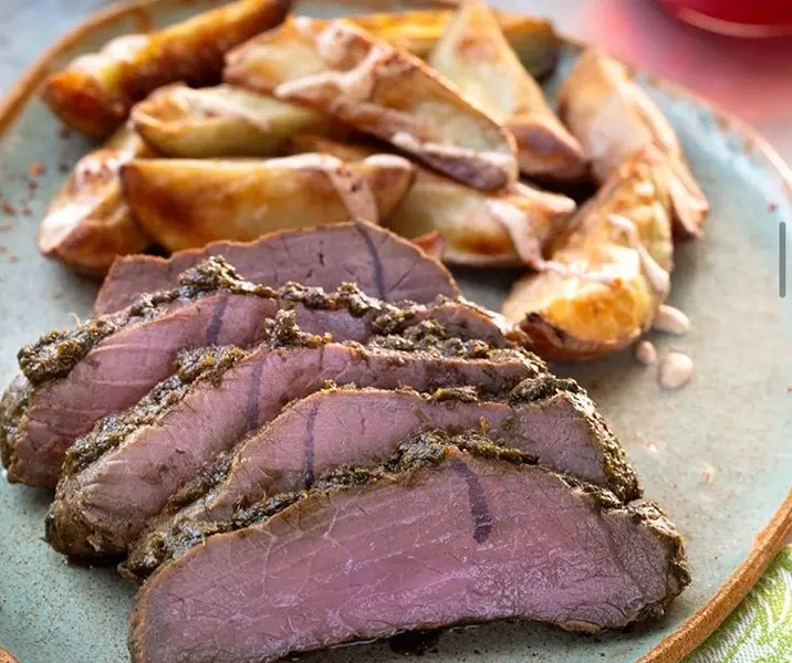 Carne al horno con cilantro acompañada de papas al merkén