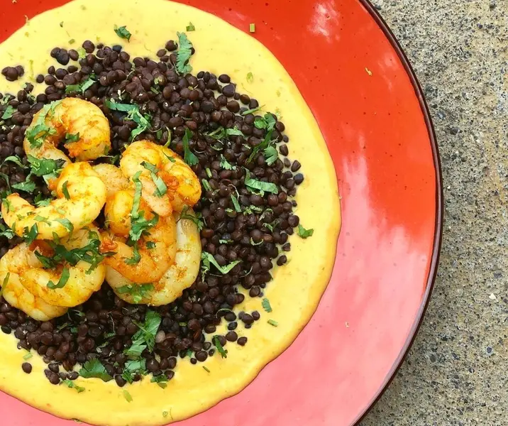 Lentejas negras con salsa de ají amarillo y camarones sazonados
