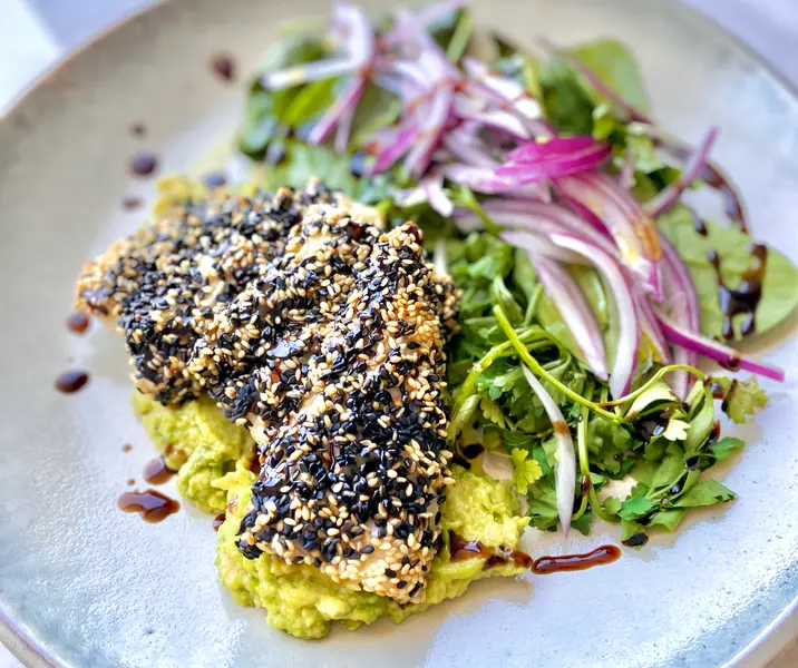 Merluza en costra de sésamo y ensalada de espinaca palta