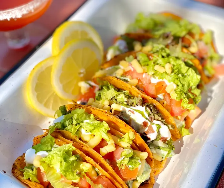 Tacos de chili de porotos negros y crema de palta y cilantro