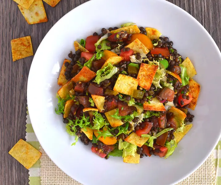Ensalada de lentejas negras con chips de tortilla