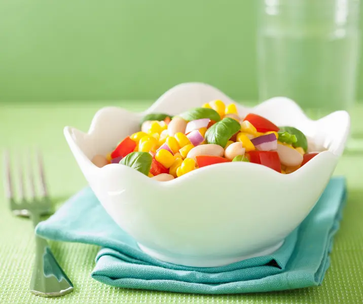 Ensalada de porotos blancos, choclo, tomate y mayonesa