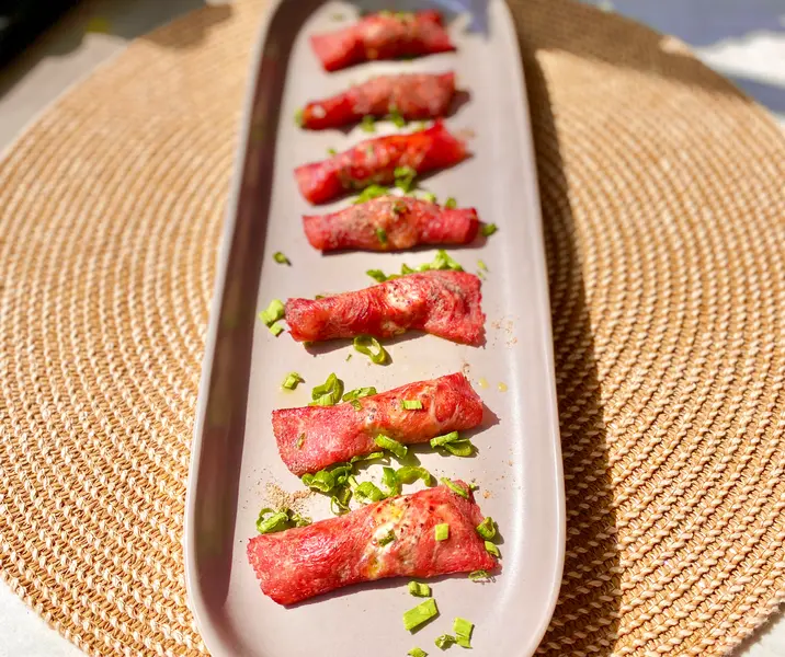 Rollos de carpaccio de carne rellenos con quínoa apanado en pimienta
