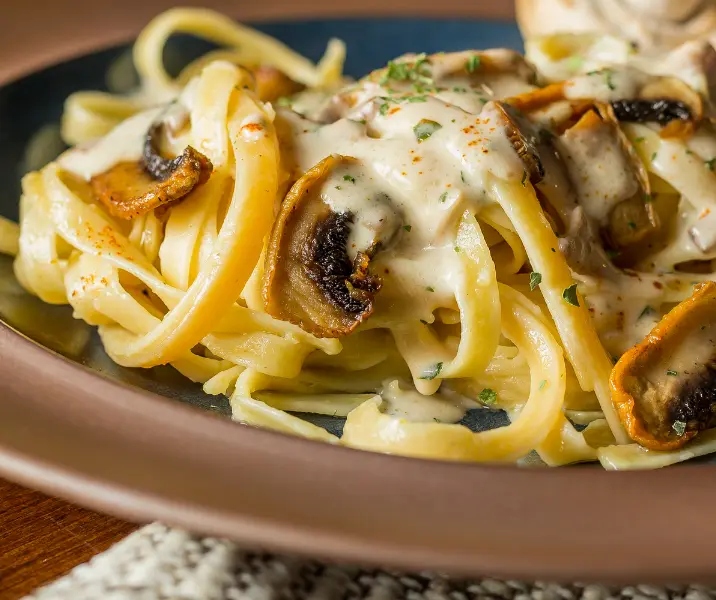 Tallarines con crema, champiñones, palmitos, aceitunas y choclo vegano