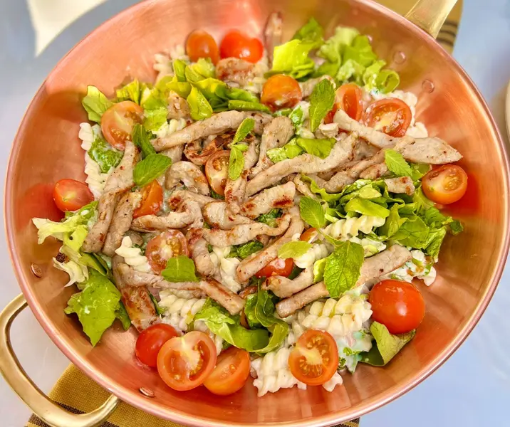 Ensalada de medallones de cerdo con pasta, lechuga y yogurt