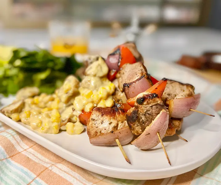 Anticuchos de cerdo con choclo a la crema y ensalada verde