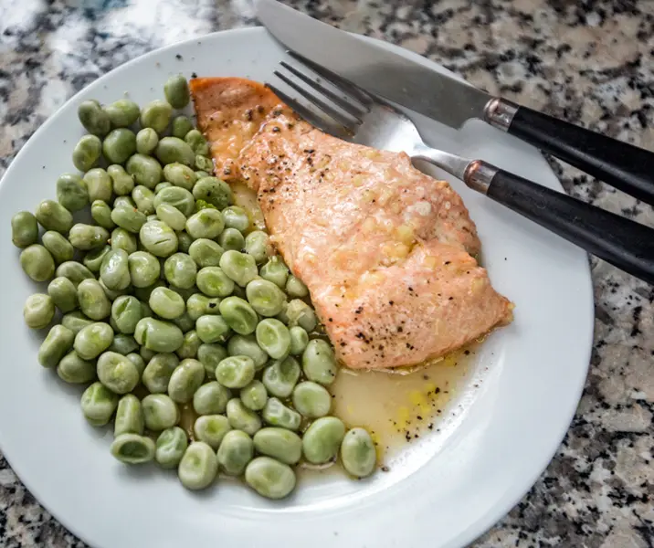 Salmón con habas y hojas verdes