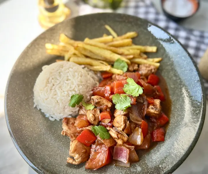Pollo saltado con arroz y papas fritas