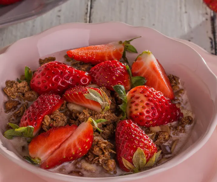 Cereales chocolatados con leche y frutillas