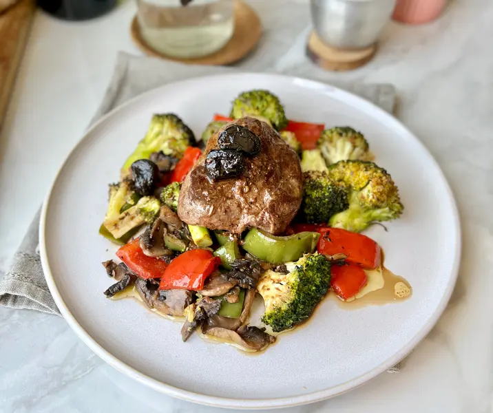 Filete en mantequilla al ajo negro y perejil acompañado de verduras confitadas