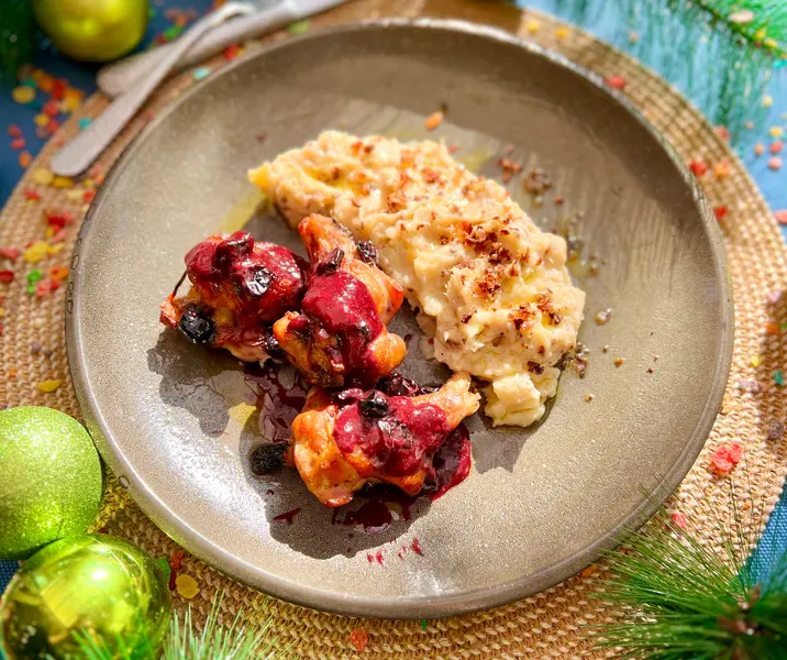 Pollo rostizado glaseado con arándanos con puré de papas con tocino