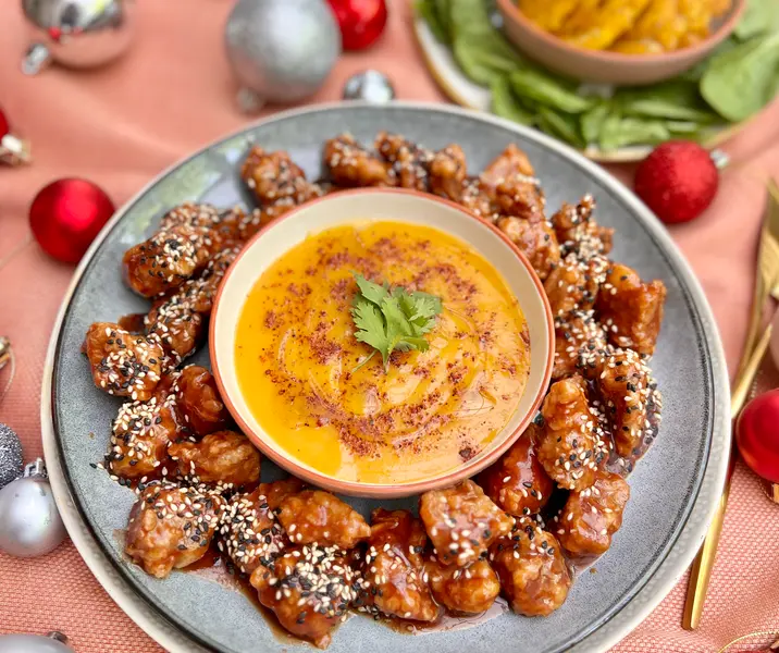 Cerdo agridulce con salsa de mango-merkén acompañado de tostones