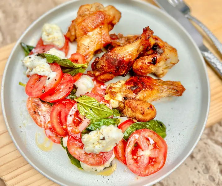 Alitas de pollo con miel y sal ahumada con ensalada caprese