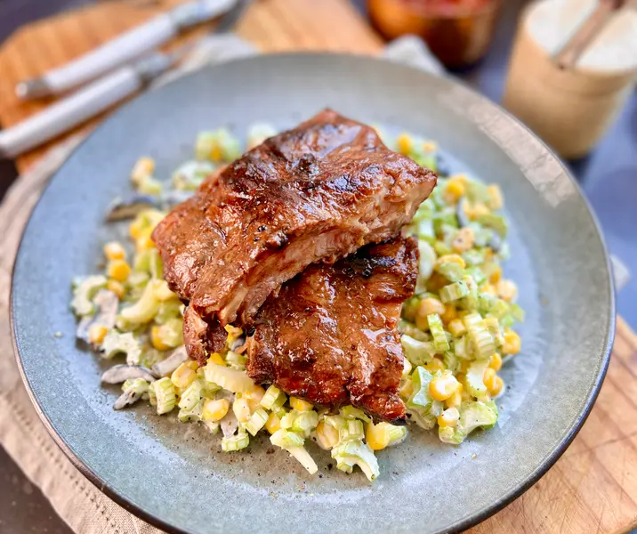 Baby back ribs a la parrilla con ensalada de apio, choclo, aceitunas y mayonesa trufada