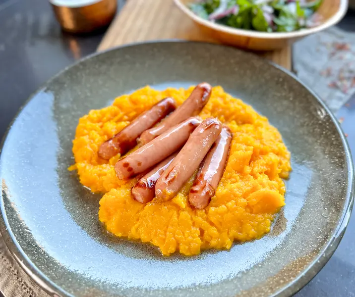 Longanicilla de campo con puré de zapallo y ensalada de rúcula