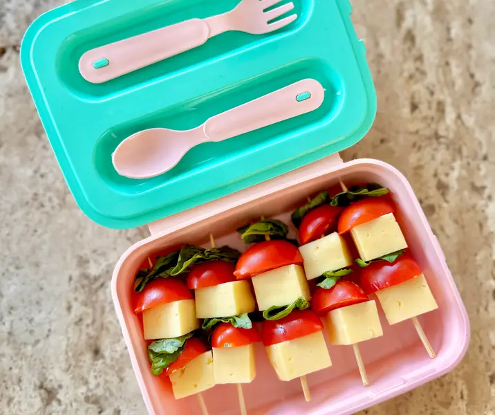 Brochetas de queso mantecoso, tomates cherry y albahaca