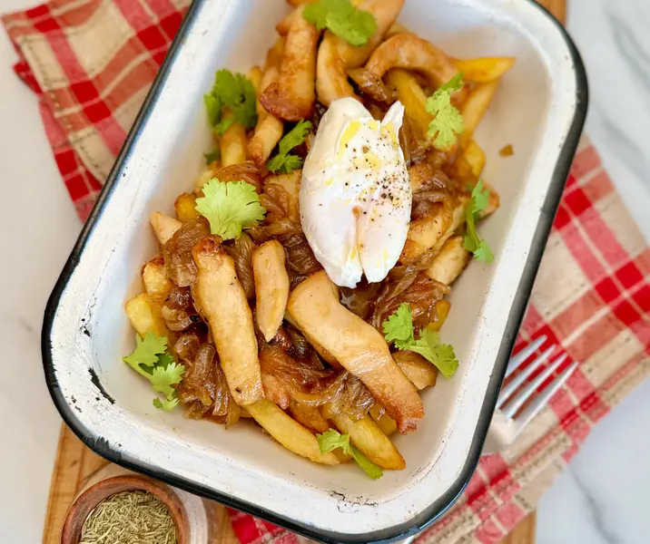 Chorrillana de pollo crocante con huevo pochado y cebolla caramelizada