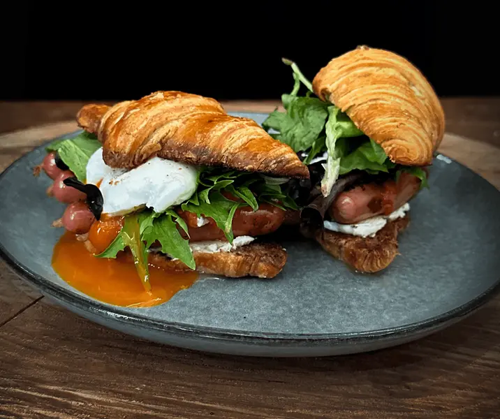 Croissant con longanicilla, huevo pochado y queso feta