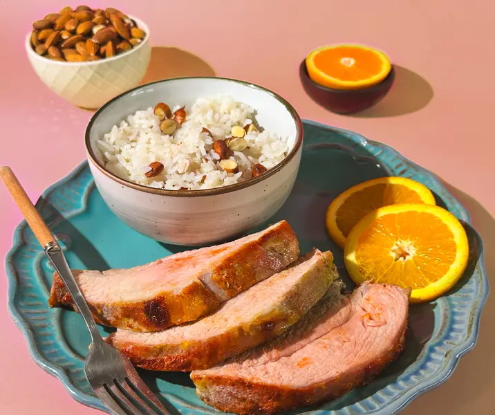 Asiento de cerdo glaseado en naranja y arroz con almendras