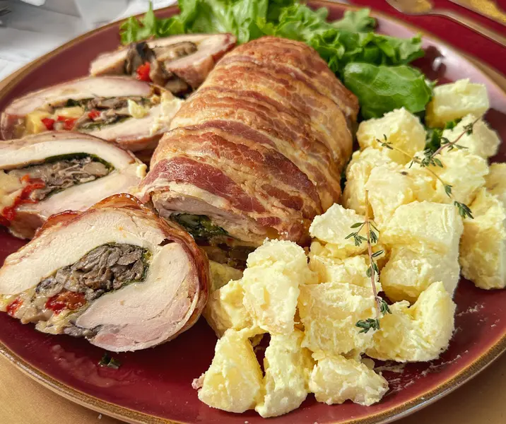 Arrollado de pollo envuelto en tocino con ensalada de papa